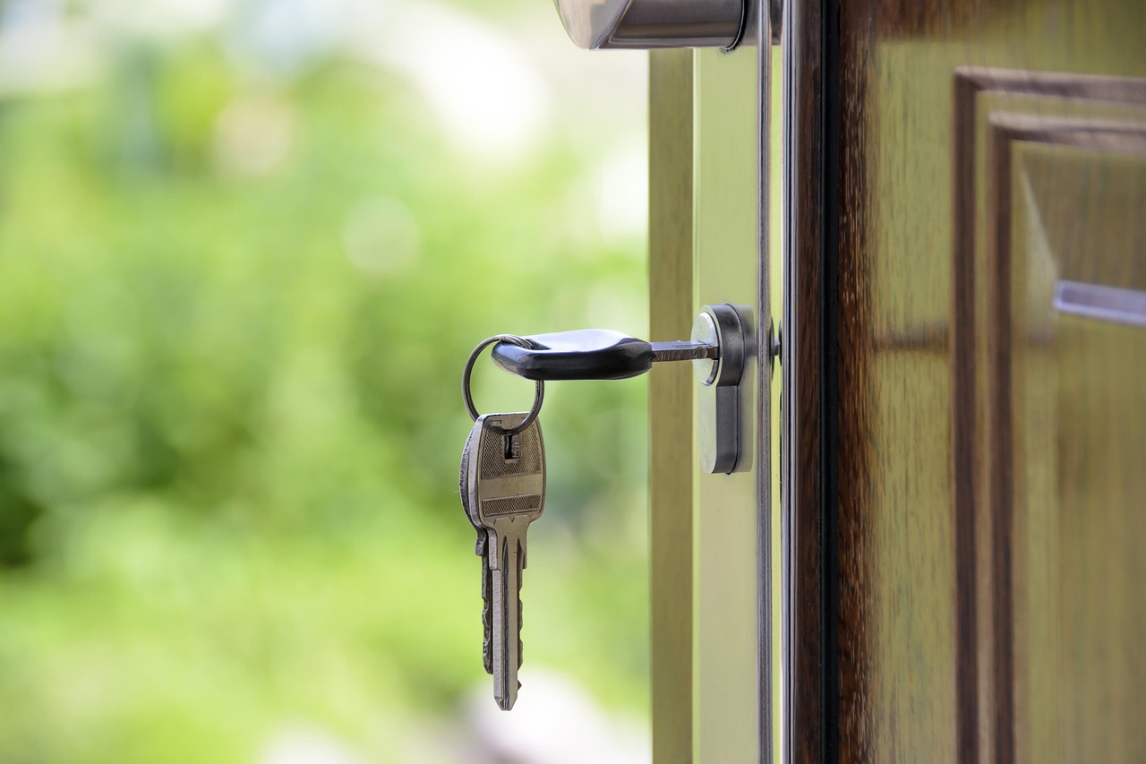 A set of keys left in the lock of an open front door