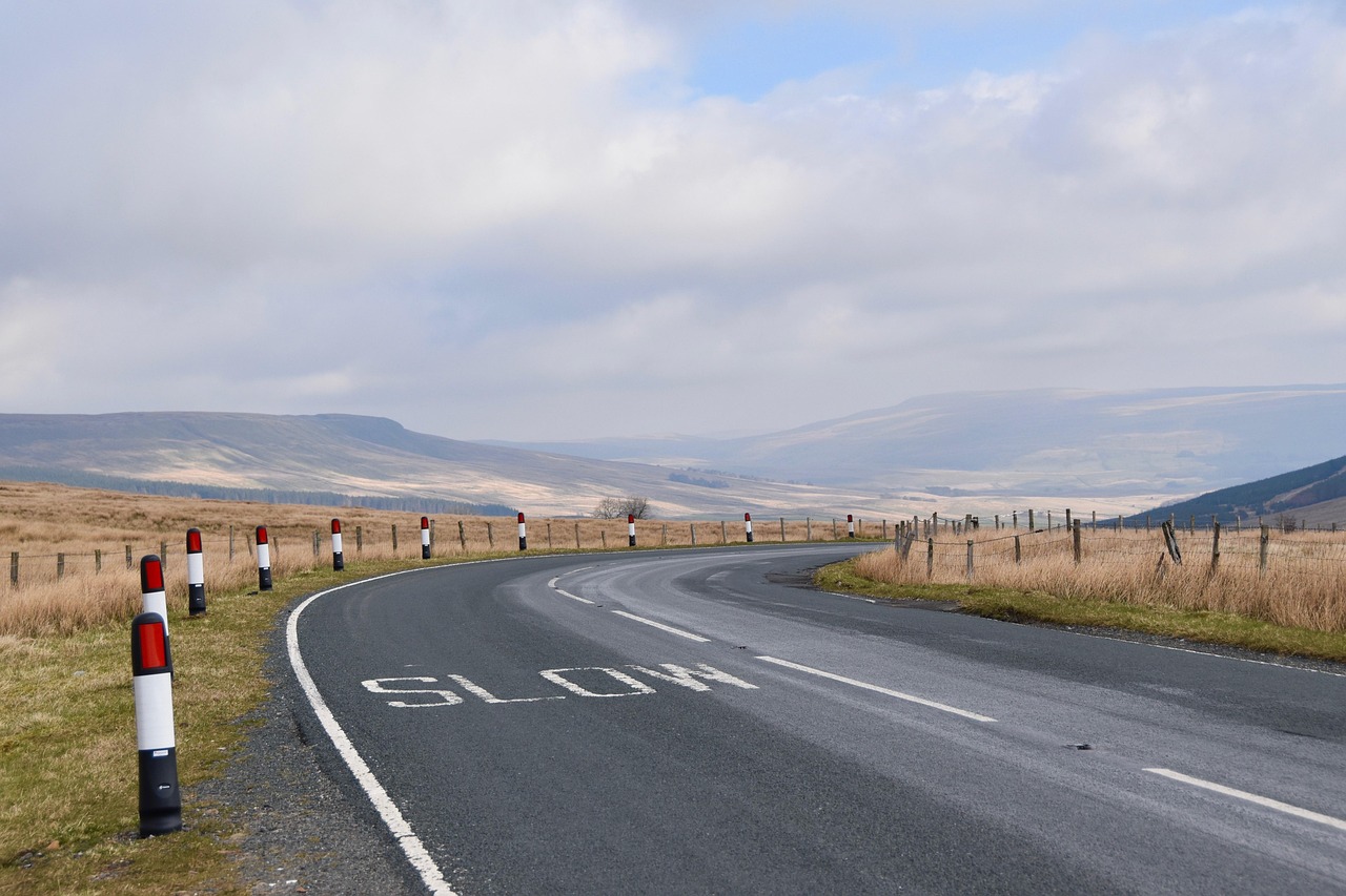 A quiet English A-road curving across open moorland under a grey sky
